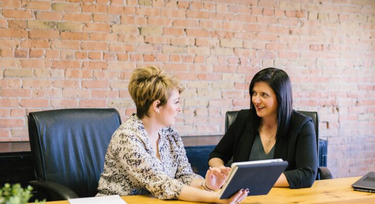 Business owner sitting at a desk with legal documents, receiving expert legal advice from a solicitor, representing the process of getting legal help for a small business