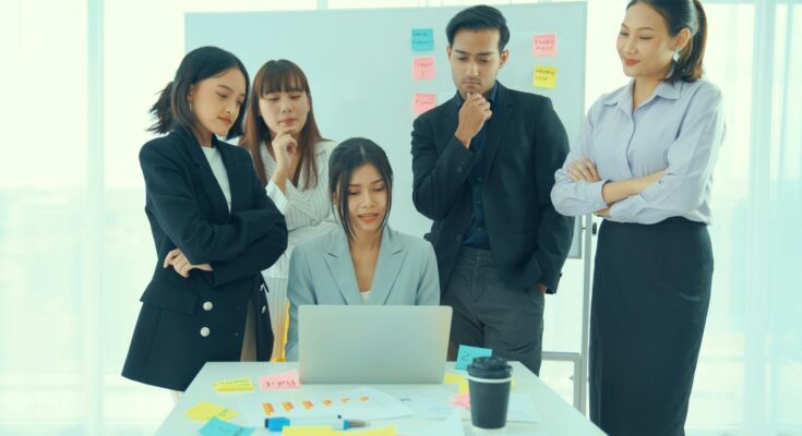 Illustration of an HR professional using a talent management system on a computer to manage employee performance and development