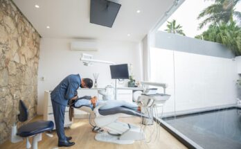 Dentist consulting with a patient in a modern dental office, discussing treatment options and maintaining good oral health through attentive patient care and communication.