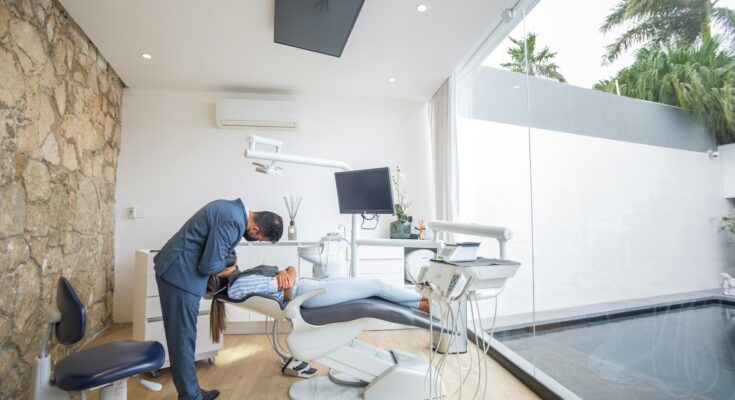 Dentist consulting with a patient in a modern dental office, discussing treatment options and maintaining good oral health through attentive patient care and communication.