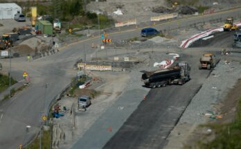 Large vehicles performing a California Bearing Ratio (CBR) test on a construction site, showcasing the evaluation of soil strength under heavy loads.